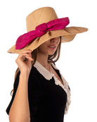 Model wearing Lilly 5" Brim Fan Straw Sun Hat with Big Fuchsia bright/hot/barbie/pink bow and matching hatband on handmade natural loomed raffia pleated wide brim hat - Shebobo