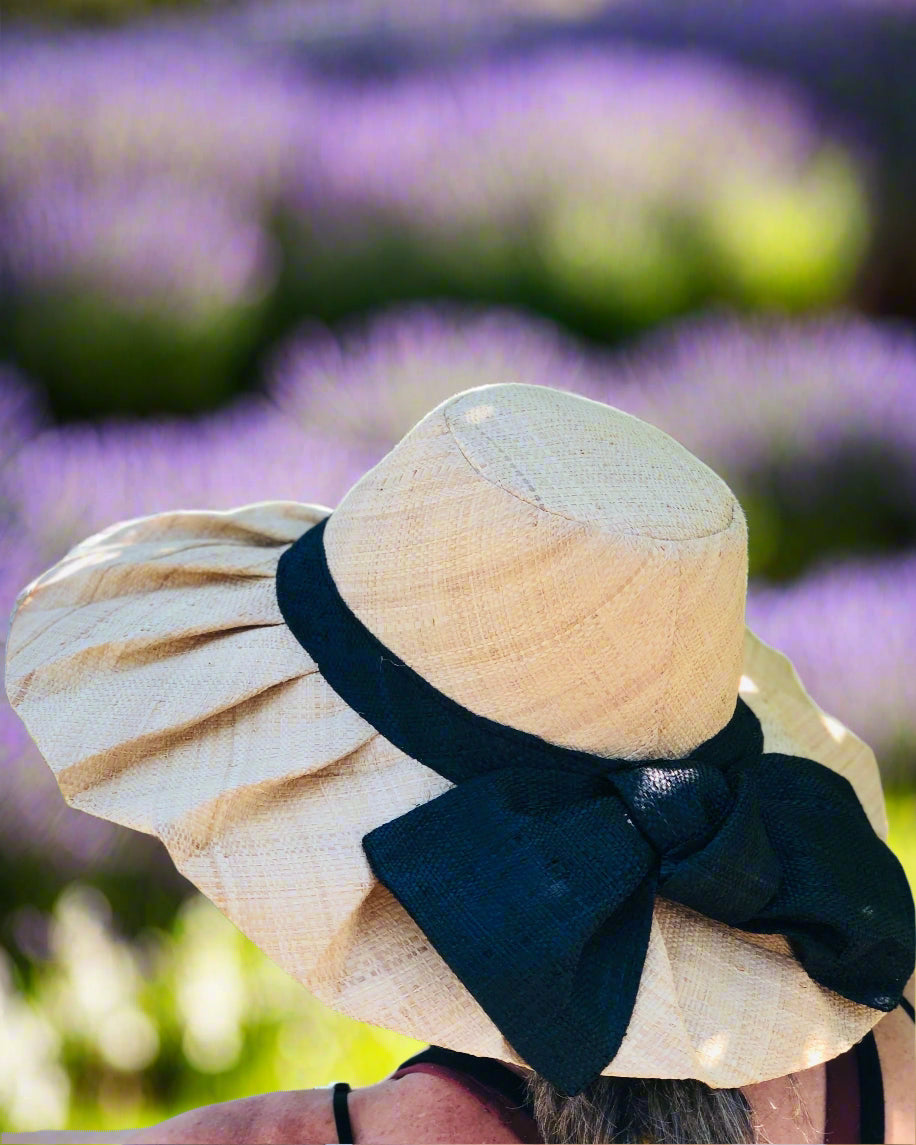 Model wearing Lilly 5" Brim Fan Straw Sun Hat with Big Black bow and matching hatband handmade natural loomed raffia pleated wide brim - Shebobo