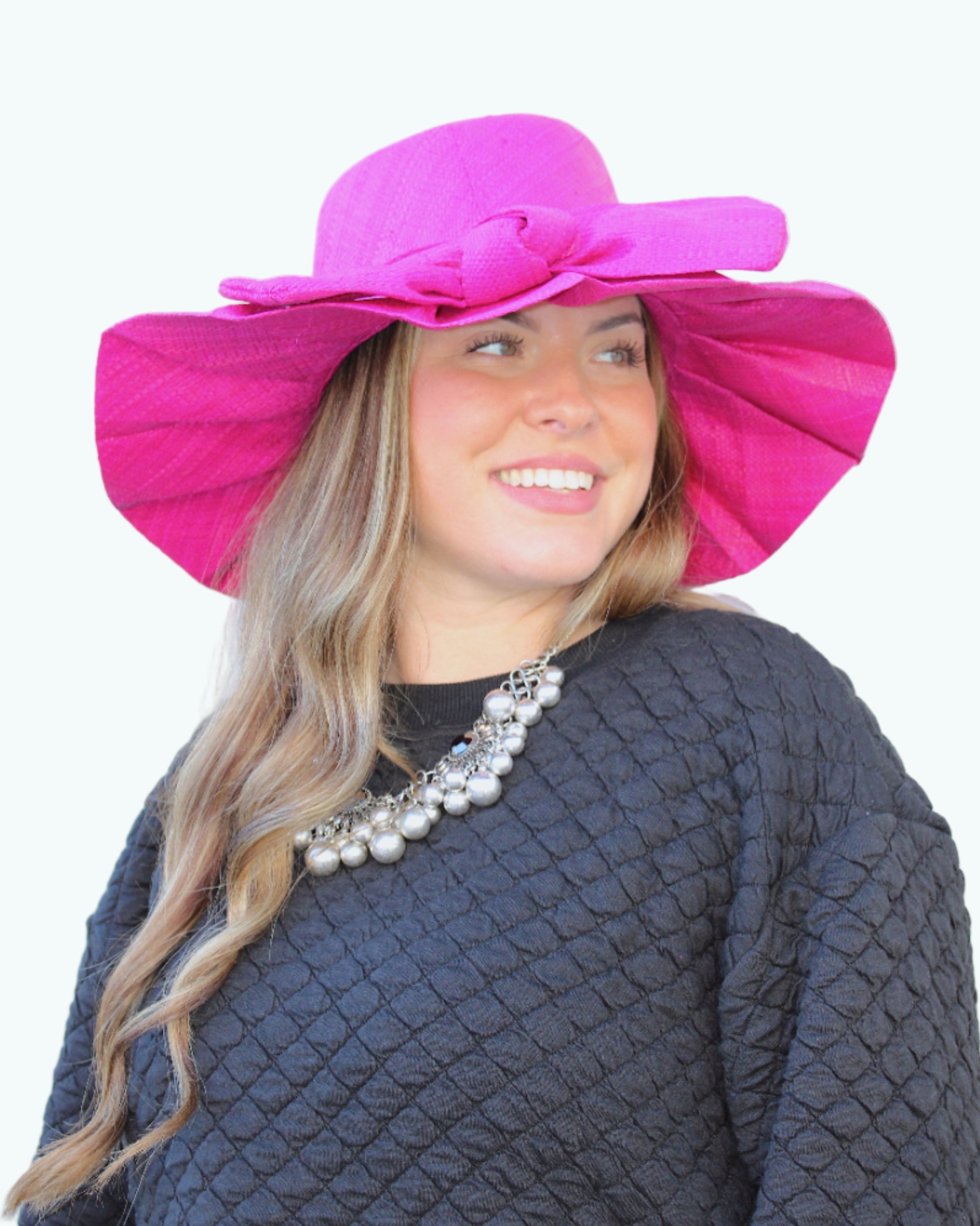 Model wearing Lilly 5" Brim Fan Straw Sun Hat with Big Bow Fuchsia handmade loomed natural raffia palm fiber in a solid hue of Fuchsia hot/bright/barbie/pink with pleated wide brim and oversized bow embellishment - Shebobo