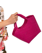 Model wearing Little Betty Mini Straw Purse Zippered Handbag handmade loomed raffia palm fiber in a solid hue of fuchsia bright/hot/barbie/pink petite small bag with zipper closure - Shebobo