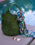 Luca Macrame Diamonds Crochet Straw Handbag handmade knotted natural raffia palm fiber in a solid hue of Deep Green forest/army/dark/green in a multi-texture circular pattern of concentric spiral links on the base, cross-hatch x pattern up 2/3rds of the bag, and geometric diamond flower pattern around the top third, with diamond pattern on the base of the shoulder strap handles with tubular loop handle tops - Shebobo (with Poppy Dreams Scarf Wrap)