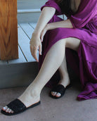 Model wearing Lulu Macrame and Crochet Diamond Straw Sandal Shoes handmade natural raffia palm fiber crochet and knotted macrame in a solid hue of black with geometric diamond or flower pattern in diagonal bands of texture on the top of the shoe and leather with rubber anti slip soles slide sandals - Shebobo