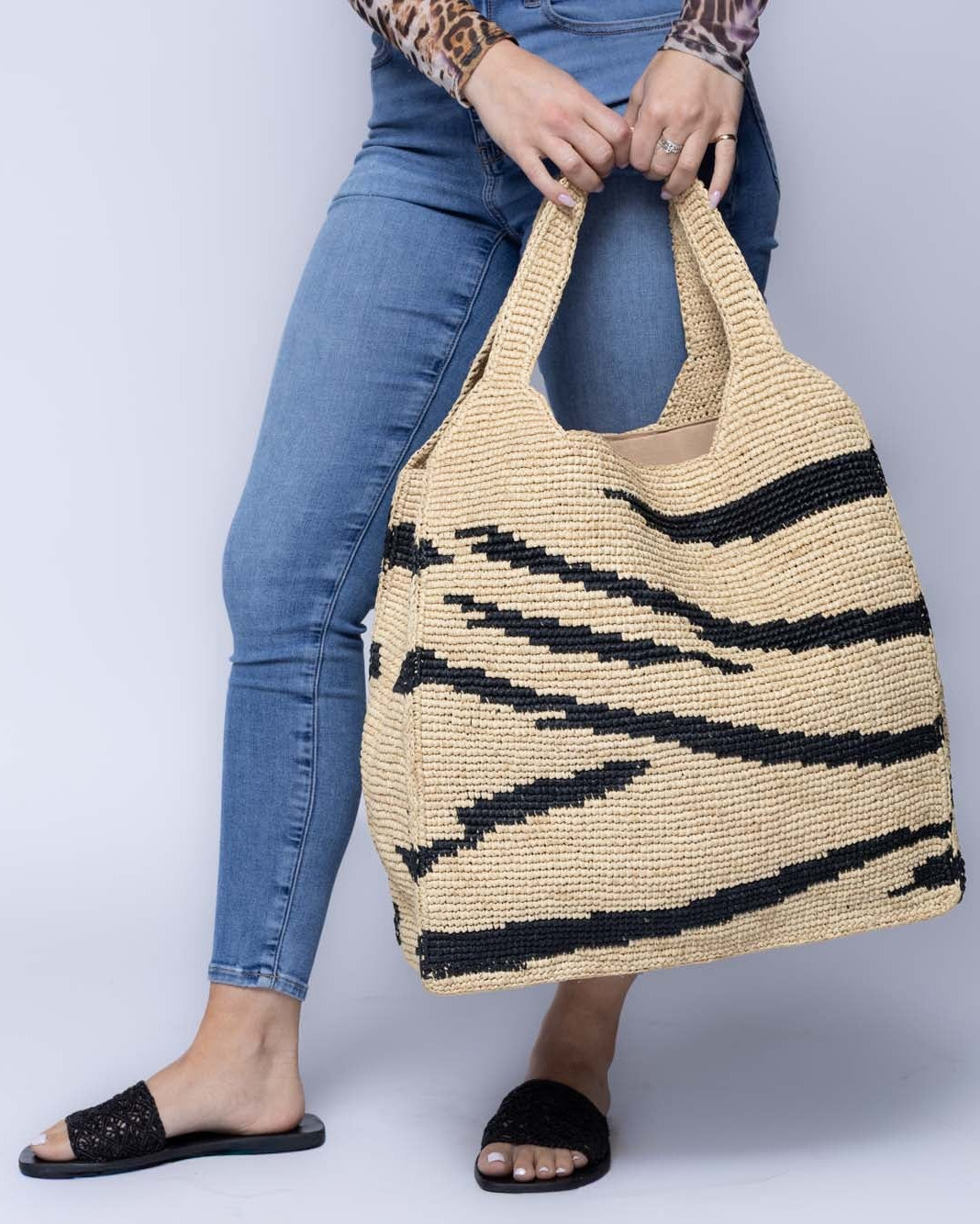 Model wearing Mamie XL Crochet Straw Basket Handbag handmade crochet natural raffia palm fiber in a two tone natural and black zebra stripe pattern purse beach bag - Shebobo