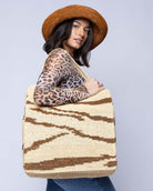 Model wearing Side view Mamie XL Crochet Straw Basket Handbag handmade crochet natural raffia palm fiber in a two tone natural straw color and tobacco dark/cinnamon/brown zebra stripe pattern purse beach bag - Shebobo