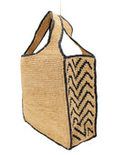 Side view Mamie Zigzag Pinstripe XL Crochet Straw Basket Handbag handmade crochet natural raffia palm fiber in a solid hue of natural straw color purse beach bag with contrasting black zigzag pinstripe pattern on the sides of the bag and matching outer edge - Shebobo