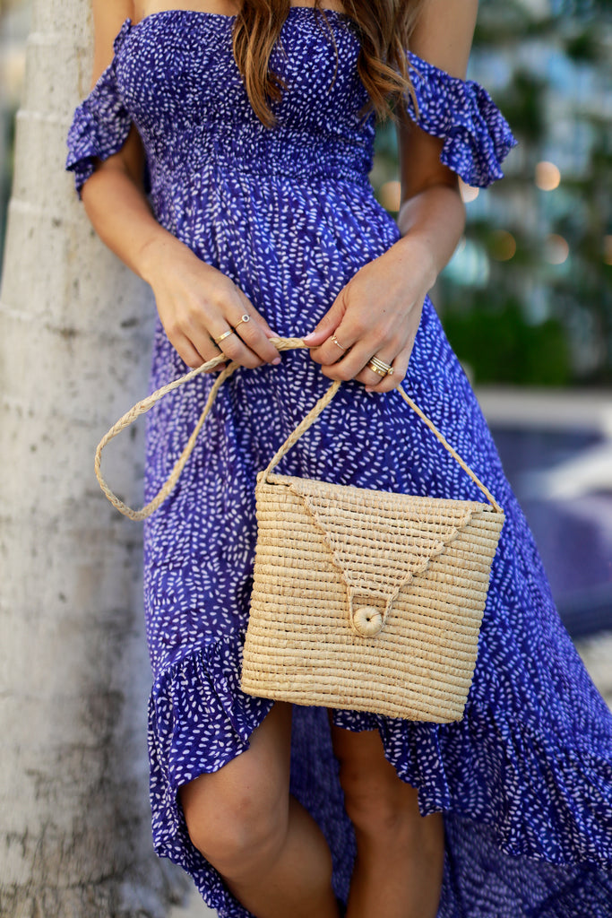 Model wearing Manteca Crochet Natural Cross Body Bag handmade woven raffia palm fiber in horizontal bands with button/loop closure and braided strap purse - Shebobo