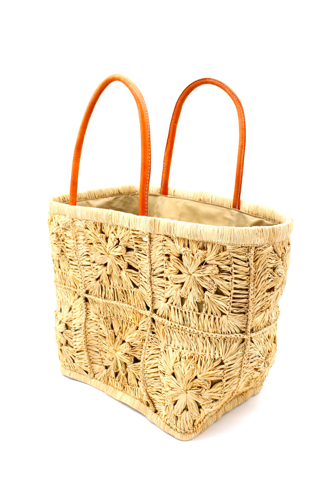 Side view Marie Flower Crochet Straw Basket Bag handmade natural raffia palm fiber woven into a geometric grid of squares with a central flower per square similar to a granny square pattern handbag tote with leather handles - Shebobo