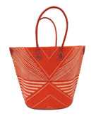 Mariposa Large Straw Tote Bag handmade loomed natural raffia palm fiber in a multi paneled pattern design of pinstripe, melange, and wide stripe combinations geometrically radiating from the center point of the bag outwards in a two tone color combination of Coral orange/red and natural straw color with a solid hue of color on the back of the bag plus leather handles and embellishments shoulder bag - Shebobo