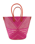 Mariposa Large Straw Tote Bag handmade loomed natural raffia palm fiber in a multi paneled pattern design of pinstripe, melange, and wide stripe combinations geometrically radiating from the center point of the bag outwards in a two tone color combination of Fuchsia hot/bright/barbie/pink and natural straw color with a solid hue of color on the back of the bag plus leather handles and embellishments shoulder bag - Shebobo