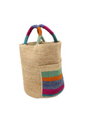 Side view Milos Caribbean Stripes Crochet Straw Basket Handbag with Pockets handmade natural raffia palm fiber in a solid hue of natural straw color on the body of the bag with multicolor wide stripe pattern of turquoise blue/green, fuchsia hot/bright/barbie/pink, denim retro/light/blue, saffron yellow/orange, and seafoam light/blue/green on both handles as well as two large external pockets tote bag - Shebobo