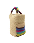 Side view Milos Riviera Stripes Crochet Straw Basket Handbag with Pockets handmade natural raffia palm fiber in a solid hue of natural straw color on the body of the bag with multicolor wide stripe pattern of umberwine bordeaux/claret/deep/dark/red/purple, denim retro/light/blue, fuchsia hot/bright/barbie/pink, teal dark/blue/green, midori lime/neon/green, and black on both handles as well as two large external pockets tote bag - Shebobo