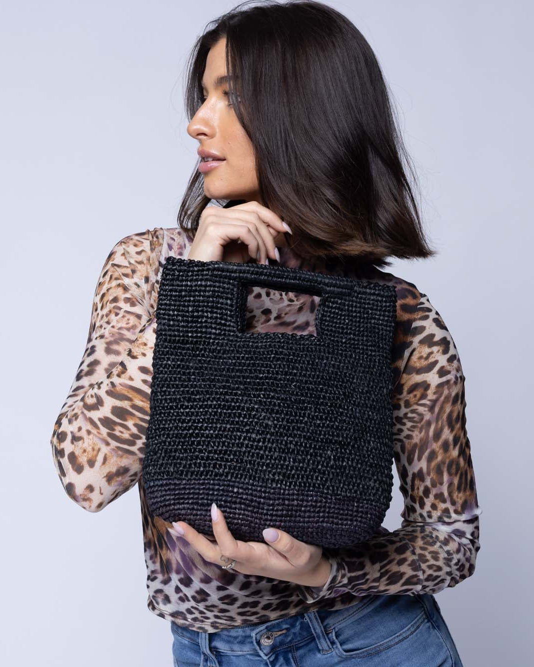 Model wearing Mini ConCon Crochet Petite Straw Basket handmade woven raffia palm fiber in a solid hue of black making a textured link pattern handbag purse small bag - Shebobo