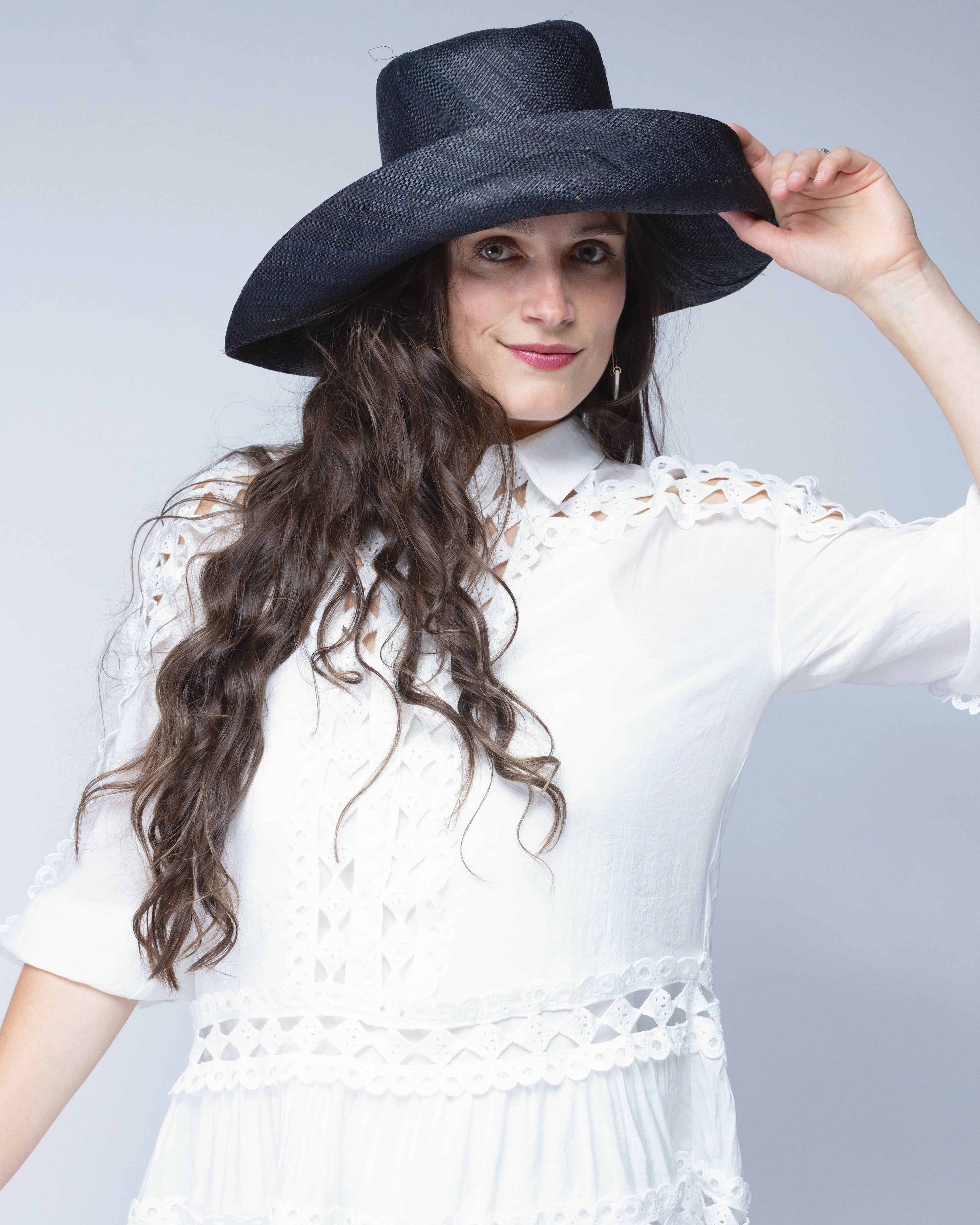 Model wearing Monica 5" & 7" Wide Brim Black Packable Straw Sun Hat handmade loomed raffia in a solid hue of black lightweight malleable flexible sun protection hat - Shebobo