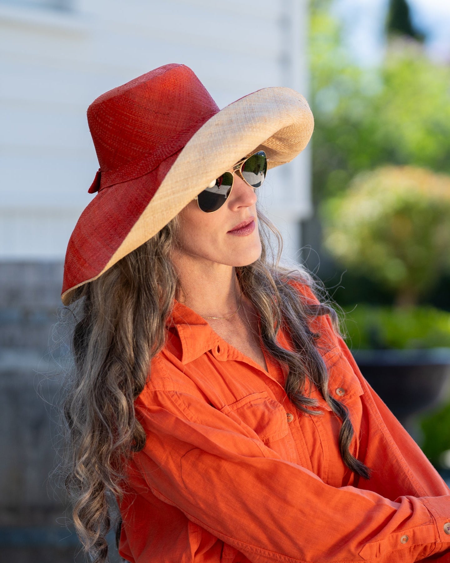 Model wearing Monica 7" Brim Two Tone Coral red/orange Straw Hat handmade loomed raffia color block pattern of the top half coral orange/red and the bottom half natural straw color - Shebobo