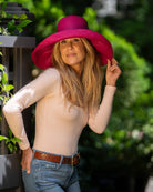Model wearing Monica 5" Wide Brim Solid Color Packable Straw Sun Hat handmade loomed raffia in a solid hue of fuchsia hot/bright/barbie/pink  - Shebobo