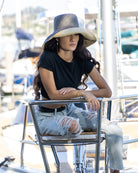 Model wearing Monica 5" wide brim two tone grey and natural packable raffia straw hat handmade loomed raffia top half grey, bottom half natural - Shebobo