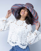 Model wearing Monica 7" Wide Brim Mulberry Swirl Multicolor Stripes Packable Straw Sun Hat handmade loomed raffia in bands of red, denim retro/light/blue, black, seafoam light/blue/green stripes create a swirl pattern - Shebobo