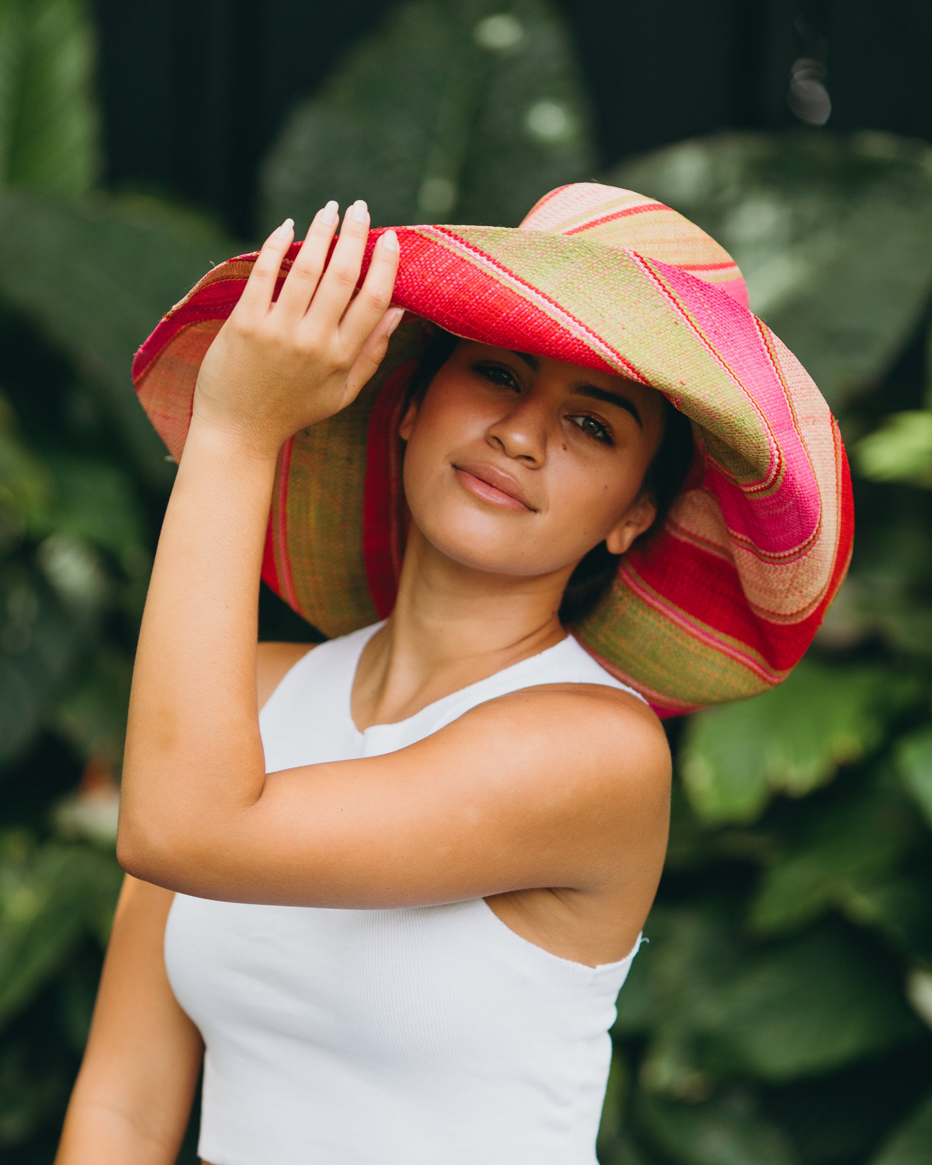 Model wearing Monica 7" Wide Brim Pink & Midori Swirl Multicolor Stripes Packable Straw Sun Hat Handmade loomed raffia in multi width bands of fuchsia pink, red, light pink, midori lime/green, and natural straw color create a swirl pattern - Shebobo