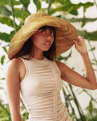 Model wearing Monica 7" wide brim cinnamon/tobacco/brown and natural pinstripes pattern shapable loomed raffia packable straw hat - Shebobo