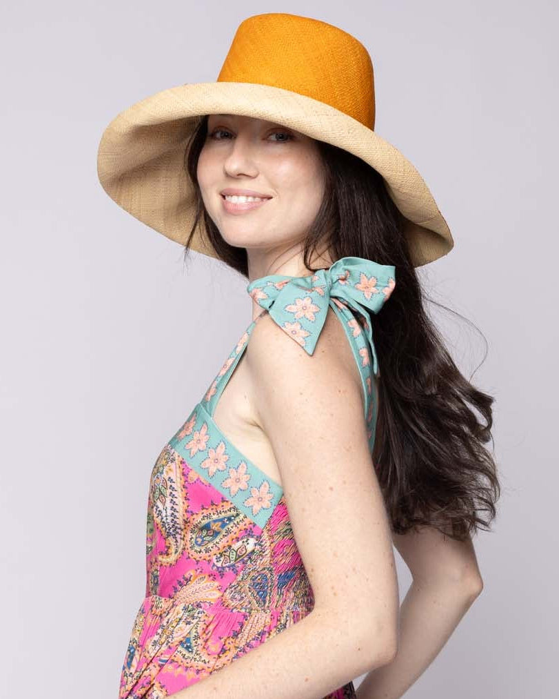 Model wearing Monica 5" & 7" Brim Two Tone Saffron Straw Hat handmade loomed raffia color block pattern of the top half saffron orange/yellow and the bottom half natural straw color - Shebobo