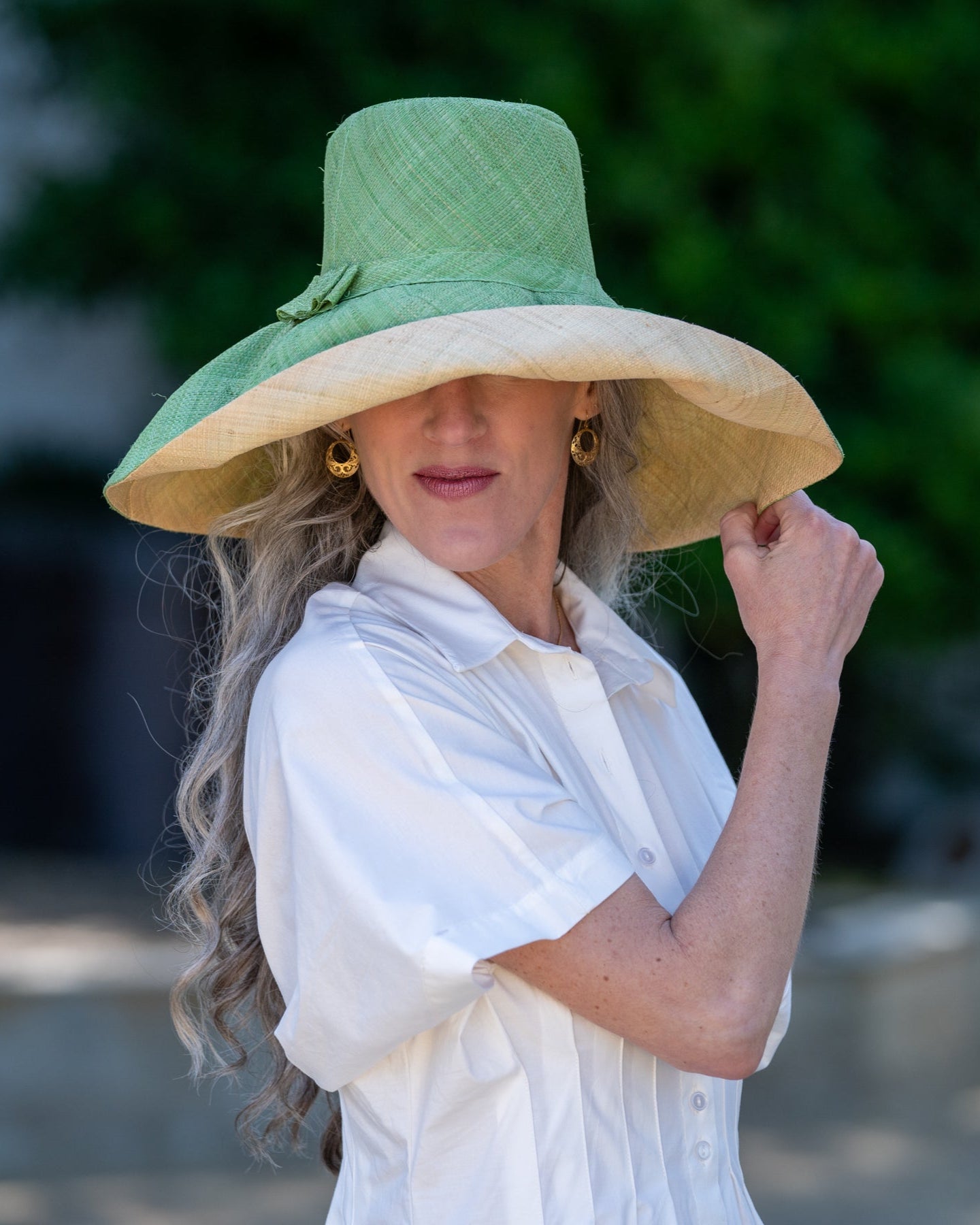 Model wearing Monica 7" wide brim handmade seafoam light/bluegreen top half and natural straw color bottom half two tone loomed raffia sun protection packable lightweight straw hat - Shebobo