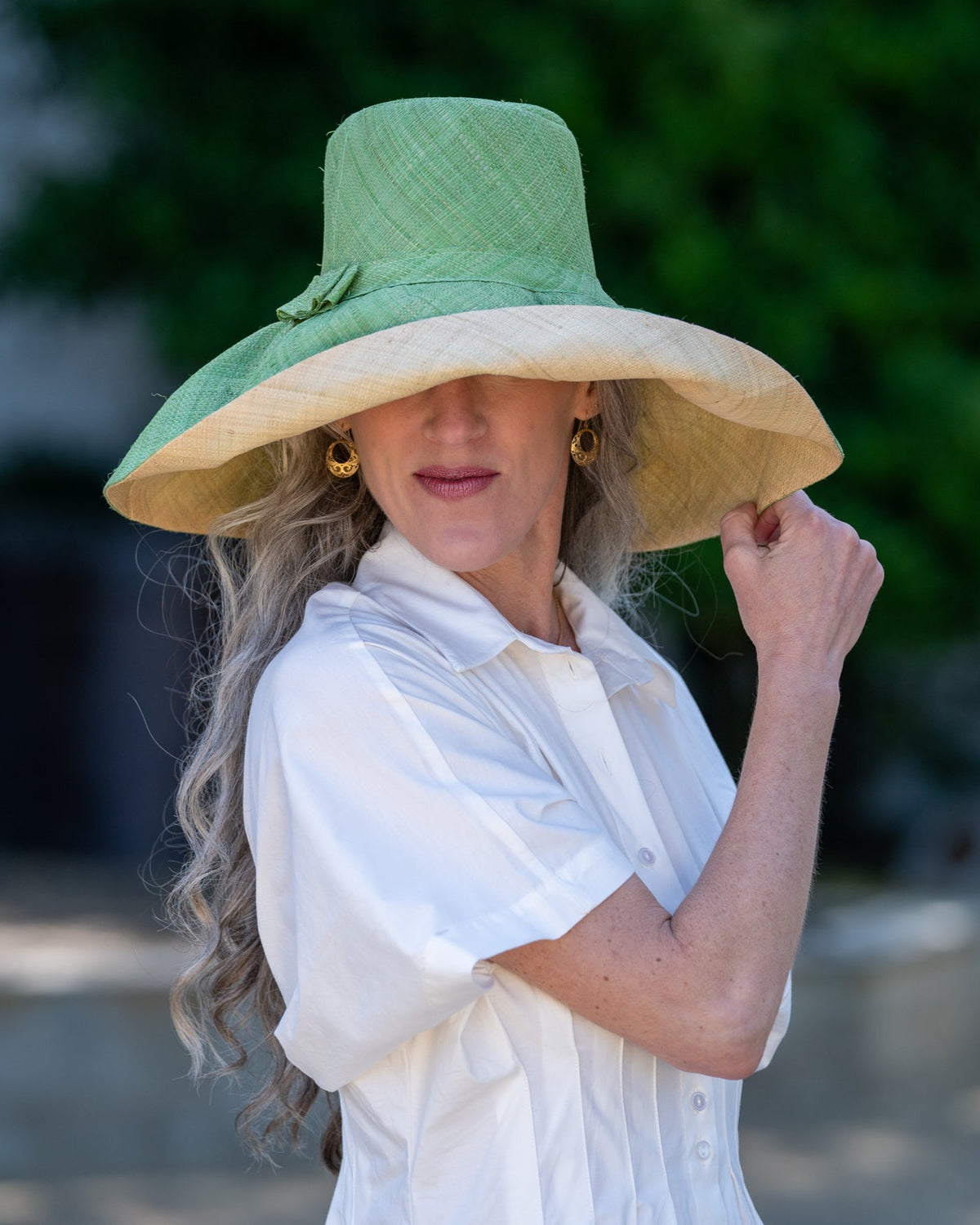 Model wearing Monica 7" wide brim handmade seafoam light/bluegreen top half and natural straw color bottom half two tone loomed raffia sun protection packable lightweight straw hat - Shebobo