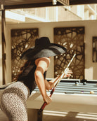 Model wearing Monica 7" Wide Brim Solid Color Packable Straw Sun Hat handmade loomed raffia in a solid hue of black - Shebobo