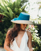 Model wearing Monica 5" wide brim handmade teal dark/blue/green top half and natural straw color bottom half two tone loomed raffia sun protection packable lightweight straw hat - Shebobo