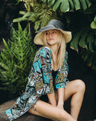 Model wearing Monica 5" & 7" Wide Brim Two Tone Black Packable Straw Sun Hat handmade loomed raffia color block pattern of the top half black and the bottom half natural straw color - Shebobo