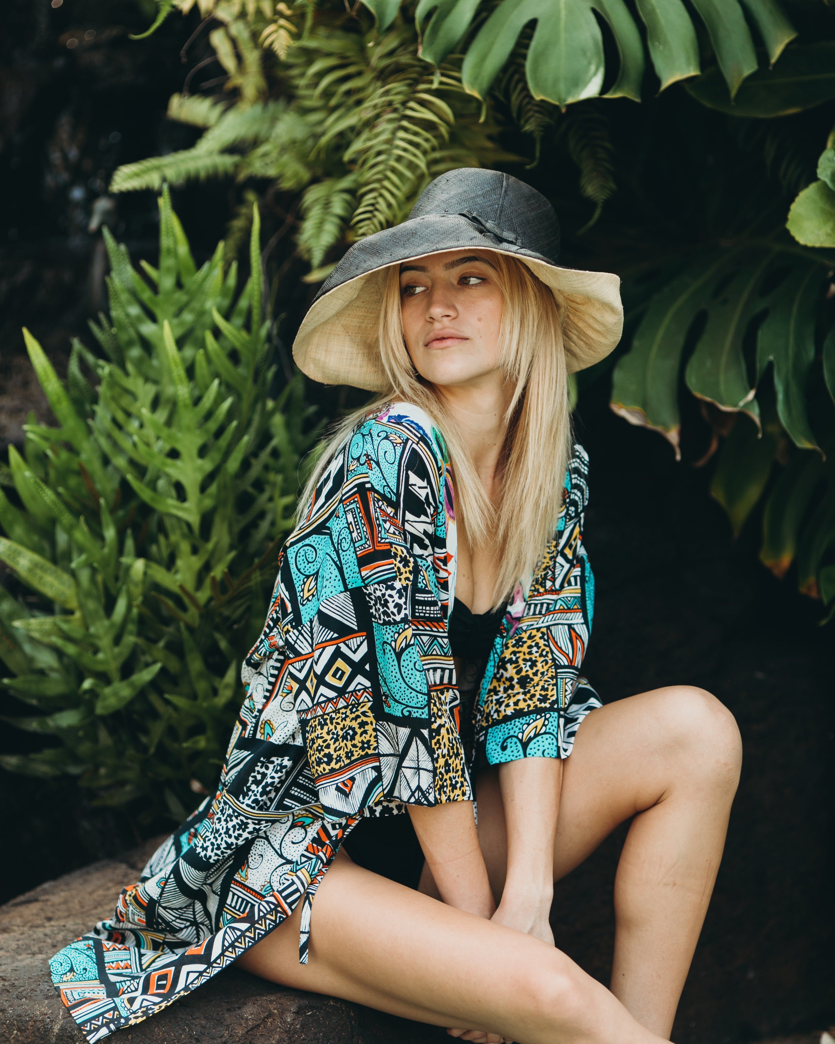 Model wearing Monica 5" & 7" Wide Brim Two Tone Black Packable Straw Sun Hat handmade loomed raffia color block pattern of the top half black and the bottom half natural straw color - Shebobo