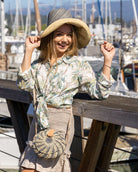 Model wearing Monica 5" Wide Brim Two Tone Grey Pinstripes Packable Straw Sun Hat handmade loomed raffia color block pattern with the top half wide bands of grey with narrow bands of natural straw color creating a pinstripe swirl and the bottom half natural straw color - Shebobo (with Clamshell Grey Two Tone Straw Crossbody Bag Purse)