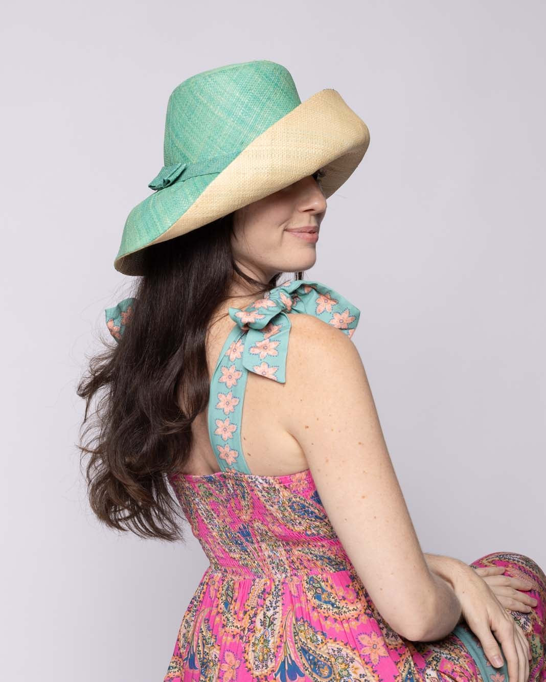 Model wearing Monica 5" & 7" Wide Brim Two Tone Seafoam Packable Straw Sun Hat handmade loomed raffia in a color block of the top half of the hat in seafoam light/blue/green and the bottom half natural straw color - Shebobo