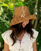 Model wearing Monica 5" Wide Brim Cinnamon Pinstripes Packable Straw Sun Hat handmade loomed raffia in wide bands of cinnamon/tobacco/brown with narrow bands of natural straw color create a striped swirl pattern - Shebobo