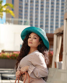 Model wearing Monica 5" Wide Brim Teal Packable Straw Sun Hat handmade loomed raffia in a solid hue of teal lightweight malleable flexible sun protection hat - Shebobo
