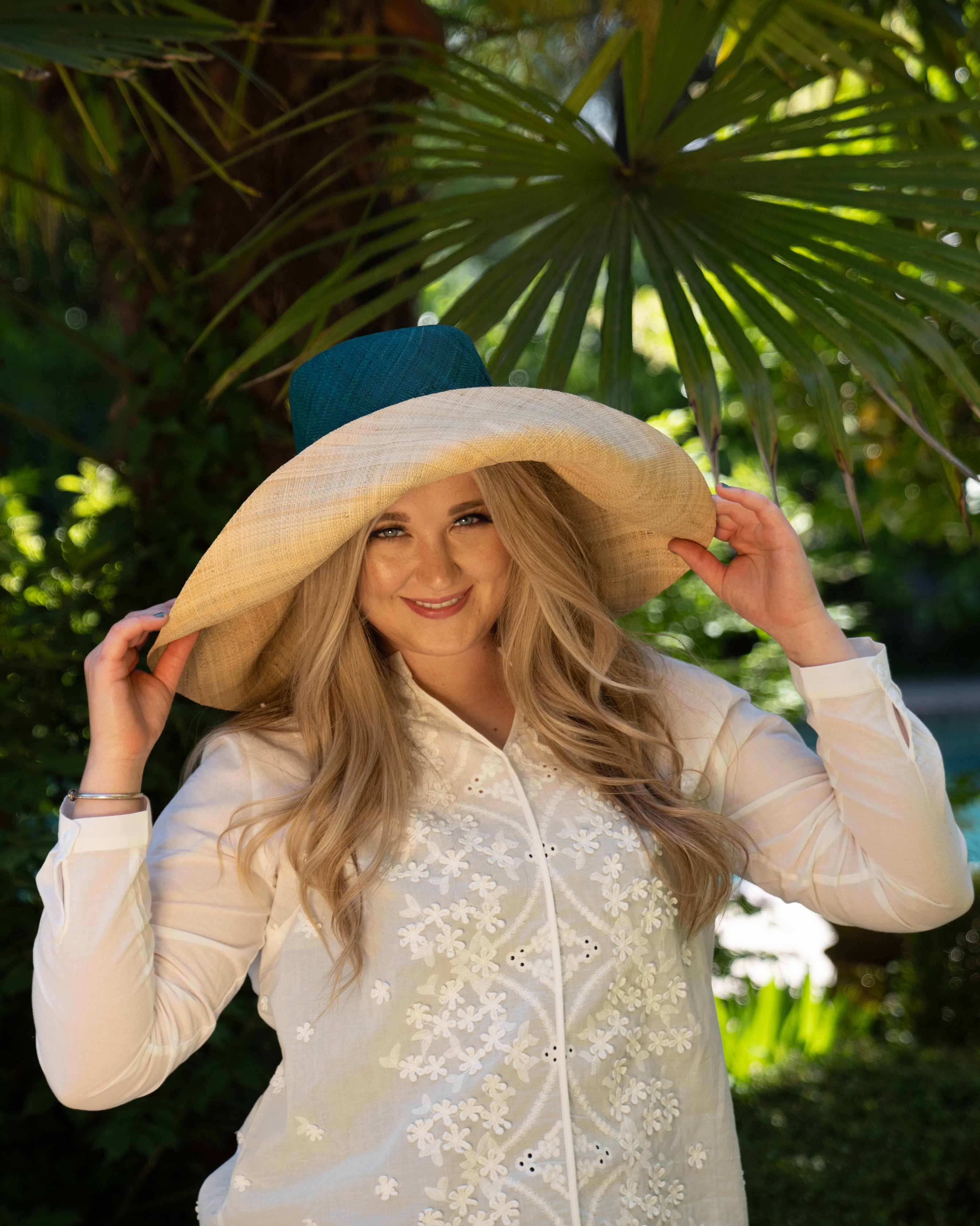 Model wearing Monica 7" wide brim handmade teal dark/blue/green top half and natural straw color bottom half two tone loomed raffia sun protection packable lightweight straw hat - Shebobo