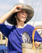 Model wearing Monica 5" Wide Brim Grey Packable Straw Sun Hat handmade loomed raffia in a solid hue of grey lightweight malleable flexible sun protection hat - Shebobo