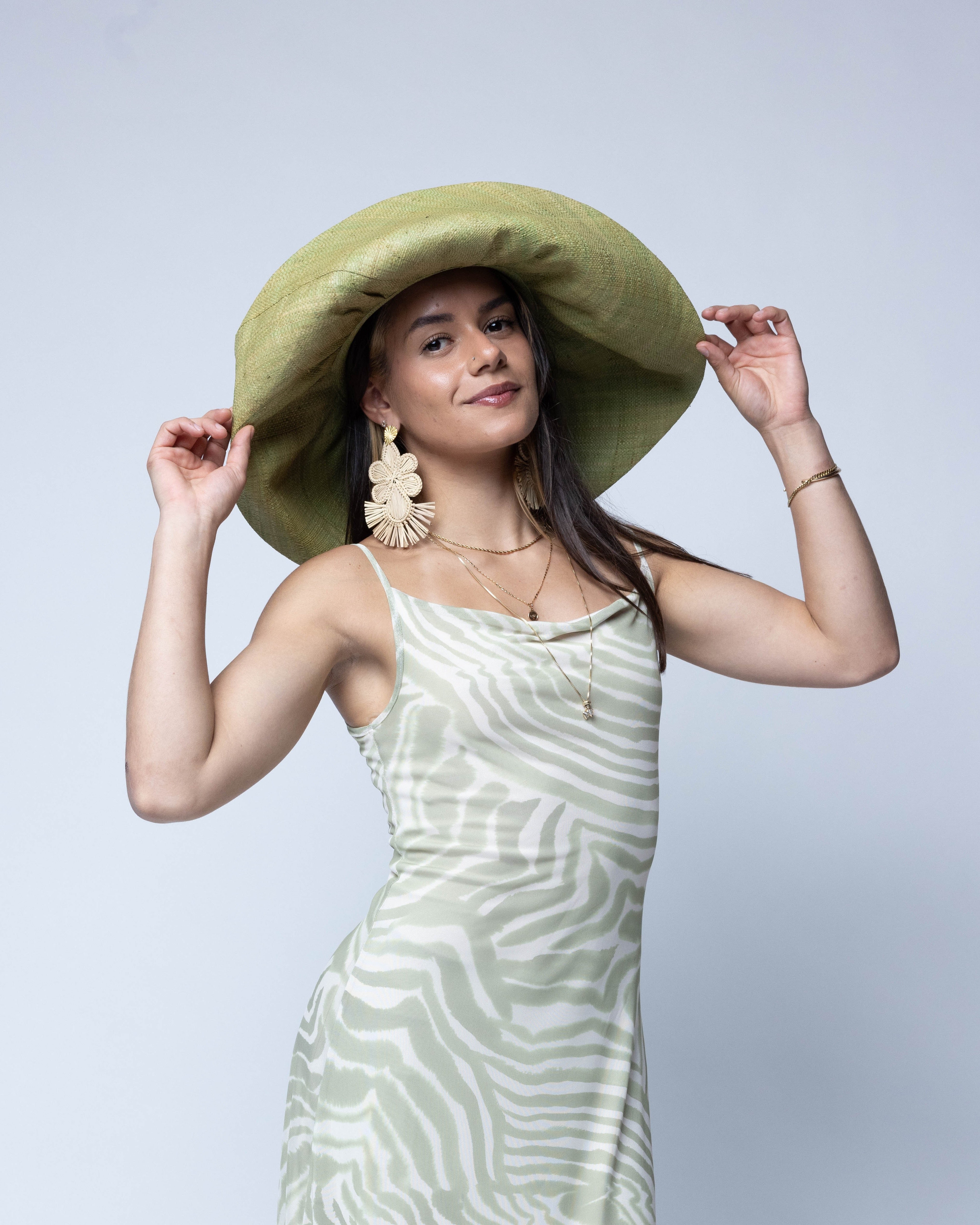 Model wearing Monica 7" Wide Brim Solid Color Packable Straw Sun Hat handmade loomed raffia in a solid hue of Matcha light/meadow/yellow/green  - Shebobo
