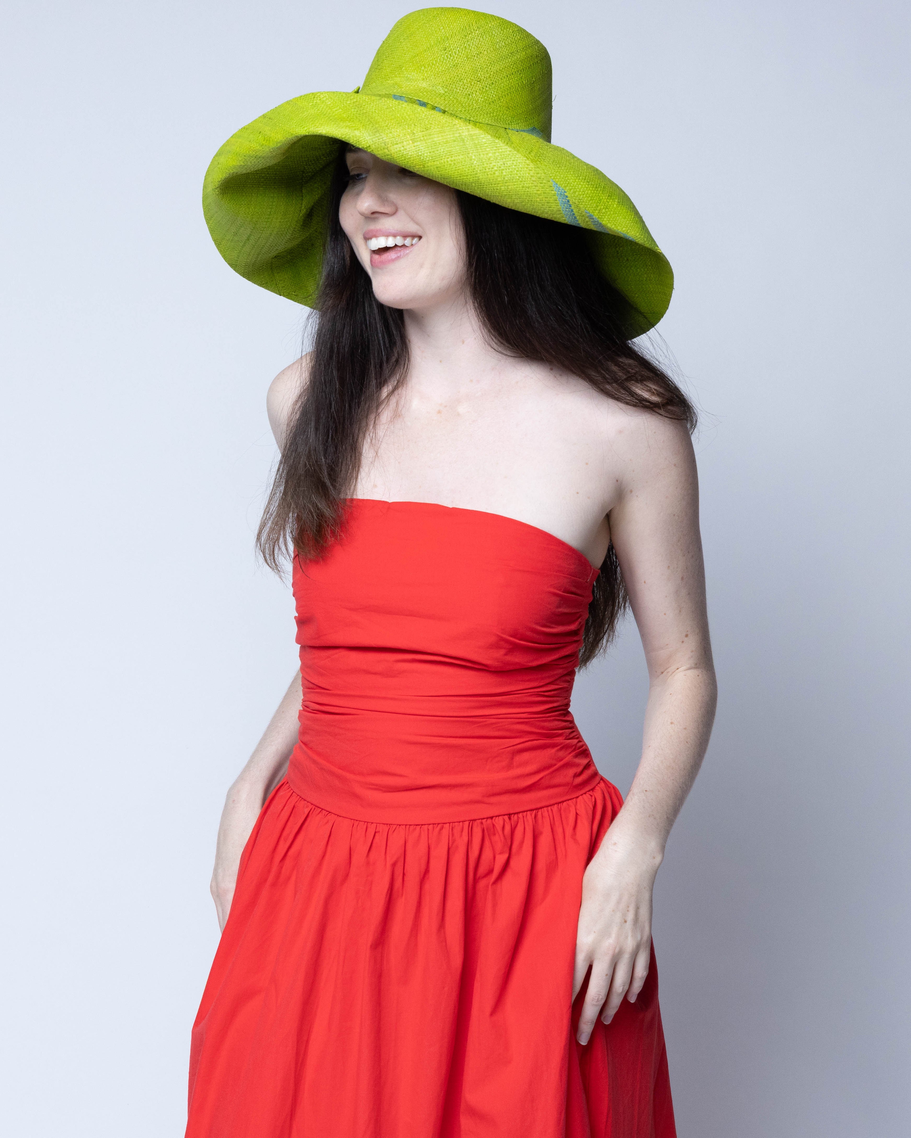 Model wearing Monica 5" & 7" Wide Brim Racing Stripe Packable Straw Sun Hats handmade loomed natural raffia palm fiber in a solid hue of midori bright/neon/lime/green with a three stripe racing stripe pinstripe pattern of turquoise blue/green that creates a swirl around the crown and brim of the hat lightweight breathable sun protection - Shebobo