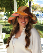 Model wearing Monica 5" Wide Brim Pink Blue Swirl Multicolor Stripes Packable Straw Sun Hat Handmade loomed raffia in multi width bands of saffron yellow, light pink, light blue, black, natural straw color etc. create a swirl pattern - Shebobo