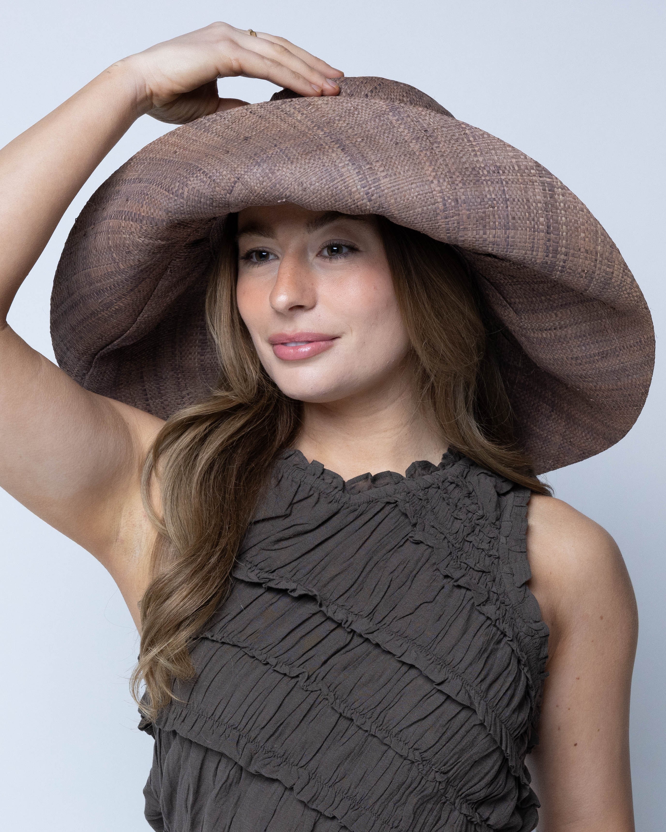 Model wearing Monica 7" Wide Brim Violet Smoke Packable Straw Sun Hat handmade loomed raffia in a solid hue of purple/grey lightweight malleable flexible sun protection hat - Shebobo