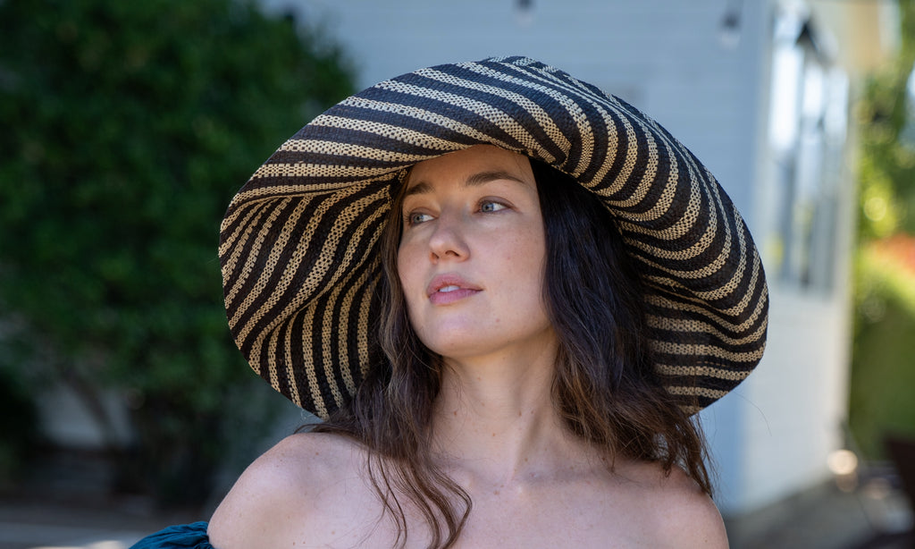 Model wearing Monica 7" Wide Brim Black and Natural Stripe Multicolor Stripe Pattern Packable Straw Sun Hat handmade loomed raffia in bands of black and natural straw color create a striped swirl pattern - Shebobo
