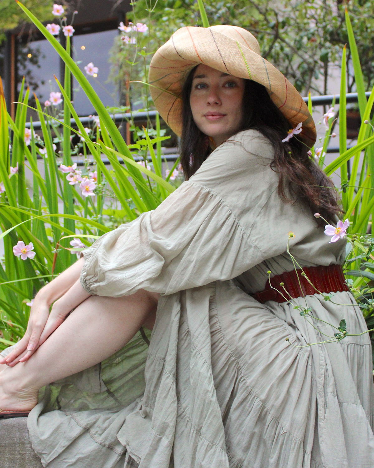 Model wearing Monica 5" or 7" wide brim natural and brights multicolor pinstripes packable raffia straw hat handmade loomed raffia in wide bands of natural straw color with narrow bands of lime green, bordeaux red, fuchsia pink, orange, cinnaon/tobacco/brown, blush orange/pink, etc. create a stripe swirl pattern - Shebobo