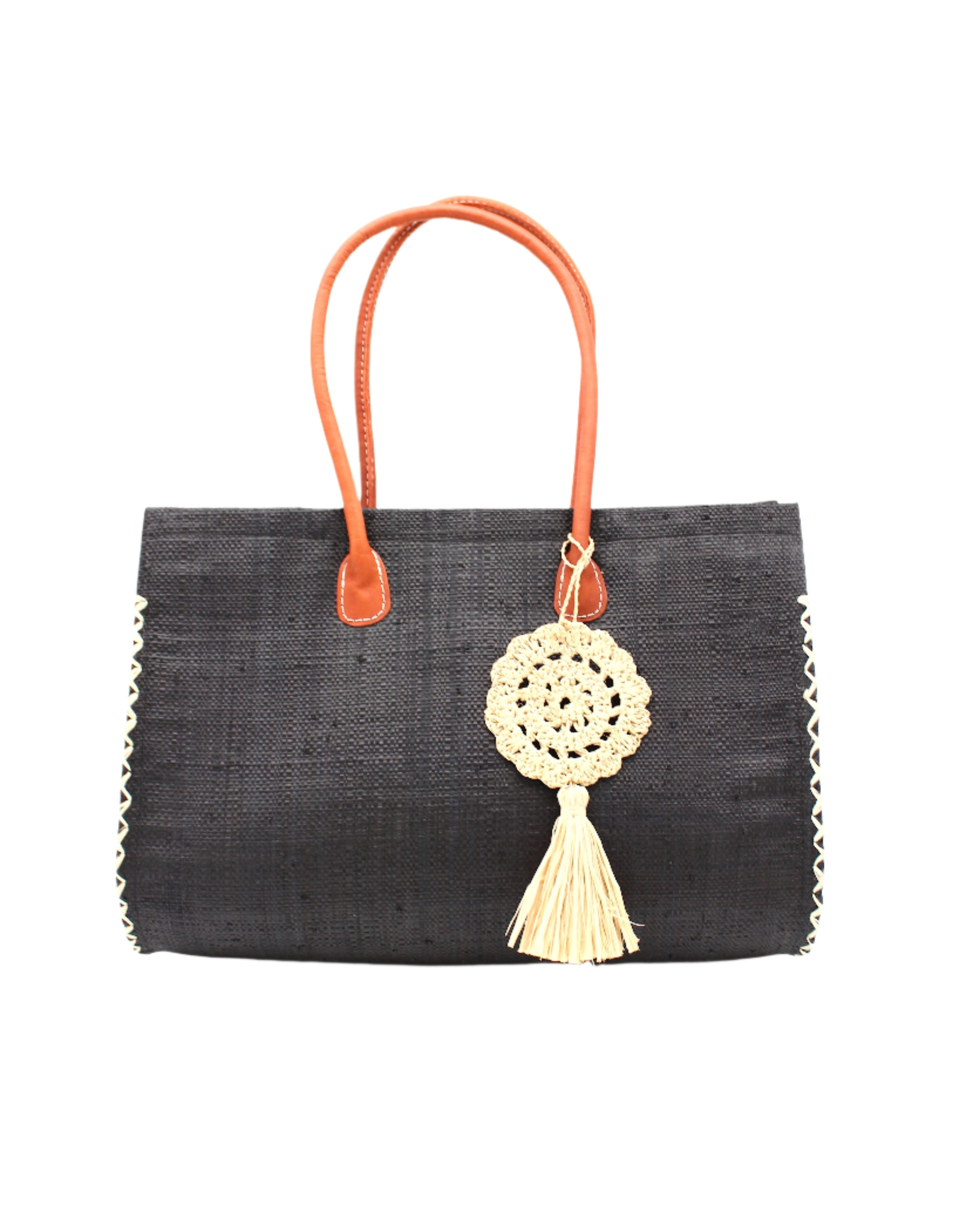 Monte Carlo Big Straw Beach Bag with Dreamcatcher Tassel Charm Embellishment handmade loomed raffia palm fiber in a solid hue of black with contrasting crosshatch stitch edging in natural straw color with matching crochet dreamcatcher disc and tuft tassel charm embellishment and leather handles oversized large handbag shoulder bag - Shebobo