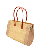 Side view Monte Carlo Wynwood Big Straw Beach Bag with Metallic Detailing Cappuccino Shoulder Bag handmade loomed raffia palm fiber in a solid hue of cappuccino light/brown/beige with incorporated woven in vegan leather gold metallic strands and leather handles purse - Shebobo