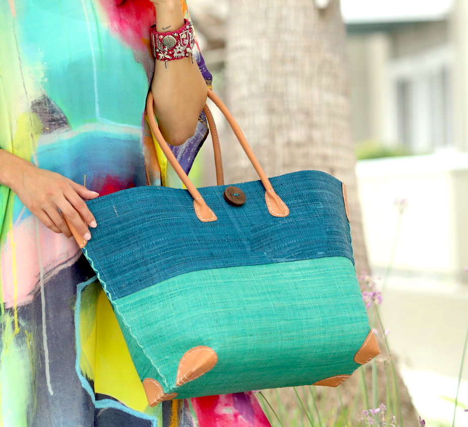 Model wearing Model wearing Monterey Two Tone Straw Tote Bag handmade loomed raffia fibers in a color block pattern of turquoise blue colored upper half, and seafoam blue/green lower half - Shebobo
