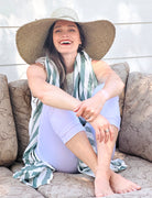 Model wearing 7" Wide Brim Natasha Ocean Mist Woven XL Straw Sun Hat handmade woven natural raffia palm fiber in a solid hue of ocean mist sage/green with matching adjustable twisted raffia hat band and and extra wide brim - Shebobo