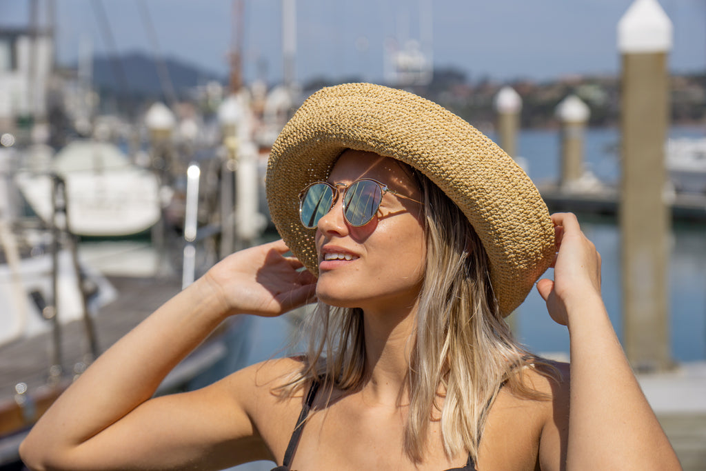 Model wearing Leor Natural crochet straw hat handmade natural straw color raffia 3" brim packable straw hat with matching adjustable braided hat band - Shebobo