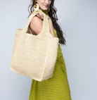 Model wearing Mamie XL Crochet Straw Basket Handbag handmade crochet natural raffia palm fiber in a solid hue of natural straw color purse beach bag - Shebobo
