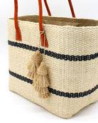 Model wearing Tassel Tie Two Layered Raffia Straw Tiered Tufts Charm Embellishment handmade crochet and brushed natural raffia palm fiber in a single hue layered tuft tassel of Natural straw color beach bag handbag charm embellishment or party decor - Shebobo