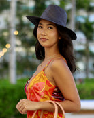 Model wearing Panama black unisex straw hat handmade 3" brim loomed raffia black travel hat sun hat - Shebobo